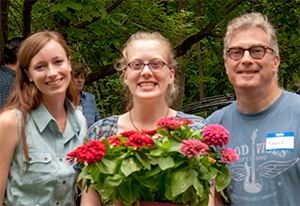 Special student volunteer Amanda Ostella (center) was honored with a special dish of flower selected for her by GSWA staff member Kelly Martin (left). Here the two stand with Amanda's proud father. Credit: GSWA/S. Reynolds